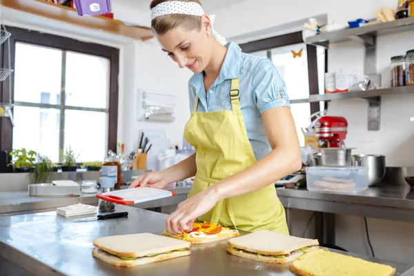 Усміхнена жінка готує бутерброд — стокове фото