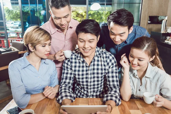 Amigos felices en el café mirando la tableta digital — Foto de Stock