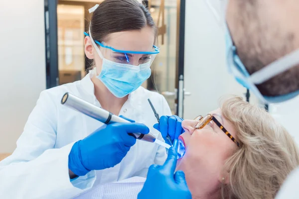 Dentista durante o tratamento da paciente idosa — Fotografia de Stock