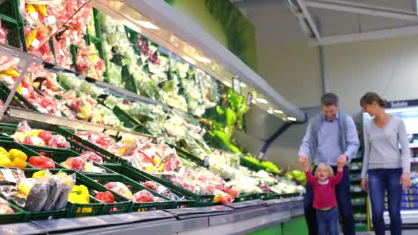 Gezin met klein kind plezier kopen van producten in de supermarkt — Stockvideo