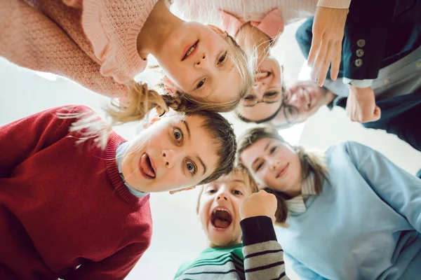 Estudiantes divertidos y profesor como un equipo en la sala de clase de la escuela — Foto de Stock