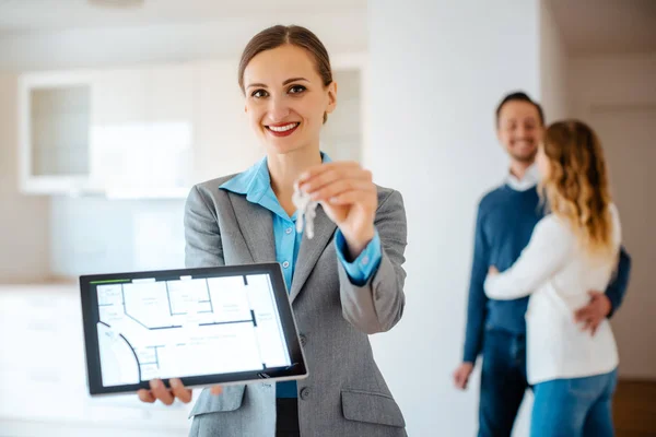 Realtor showing home keys and floorplan of apartment — Stock Photo, Image