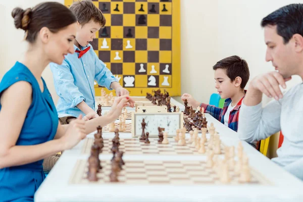 Familia jugando ajedrez en sala de torneos — Foto de Stock