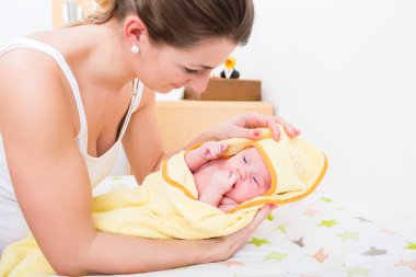 Banyo yaptıktan sonra havlu kapsayan bebek anne