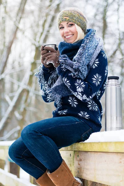 Mujer congelándose en un frío día de invierno calentándose con bebida caliente — Foto de Stock