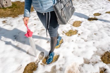 Woman walking thru the thaw making steps clipart