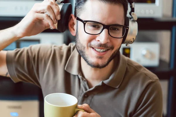 Mann som drikker kaffe og lytter til musikk – stockfoto