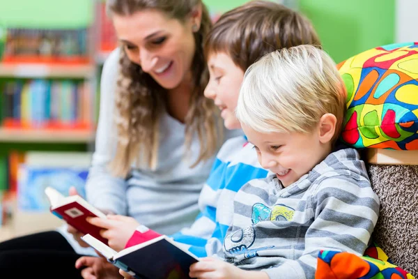 Maman avec ses enfants pour la première fois à la bibliothèque — Photo