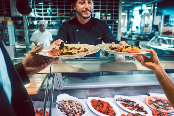 Gros plan de deux assiettes de fruits de mer et légumes servies par un chef expérimenté — Photo