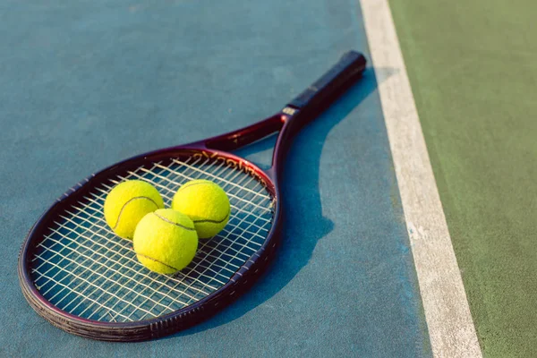 High-angle close-up of three tennis balls on a professional racket — Stock Photo, Image