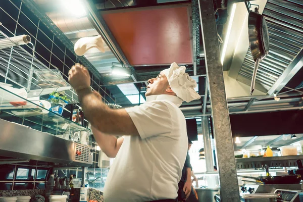 Cook tossing dough while preparing pizza in a modern Italian restaurant — Stock Photo, Image