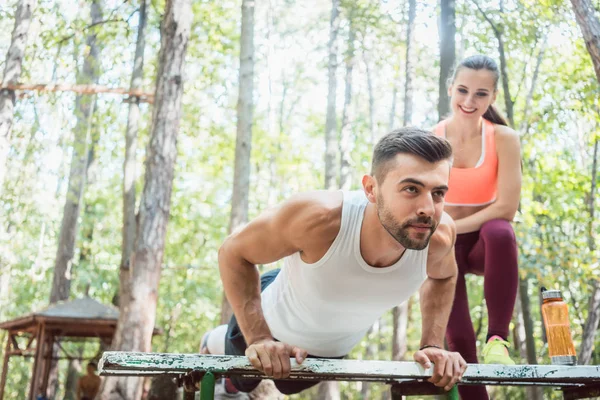 Sporty man doing push-up in an outdoor gym — Stock Photo, Image