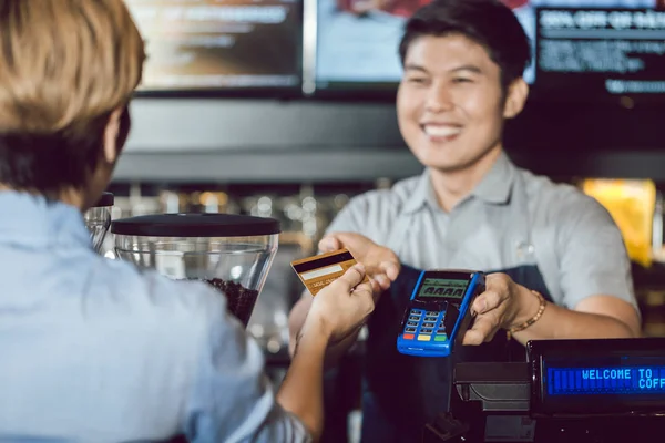 Barista dando servicio de pago al cliente con tarjeta de crédito — Foto de Stock