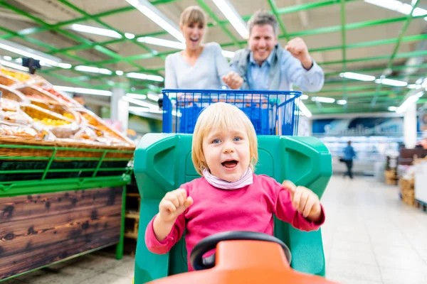 Casal de compras no supermercado usando um carrinho infantil especial — Fotografia de Stock