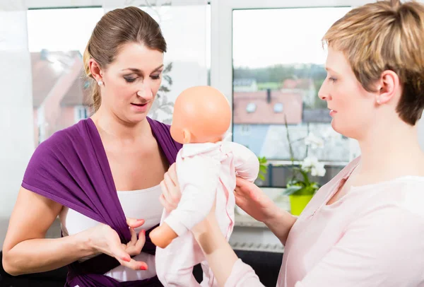 Frauen lernen, wie man Babytrage benutzt — Stockfoto