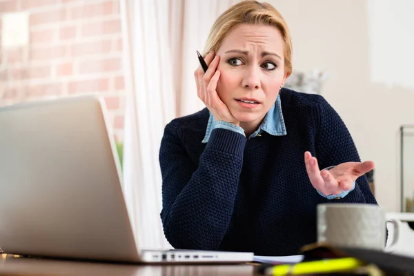 Nachdenkliche Frau schaut auf Laptop — Stockfoto