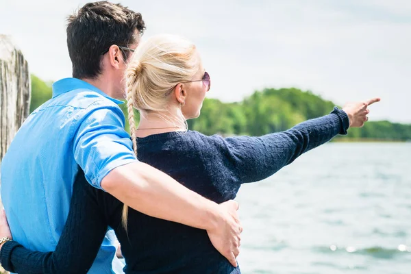 Visão traseira do casal olhando para o lago — Fotografia de Stock