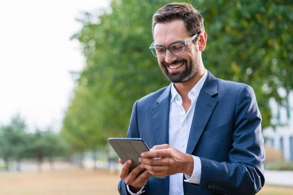 Uśmiechający się biznesmen za pomocą cyfrowego tabletu — Zdjęcie stockowe