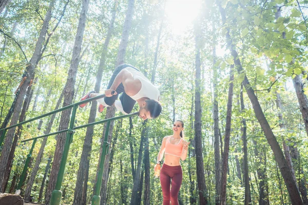 Sportive couple doing workout in outdoor gym — Stock Photo, Image