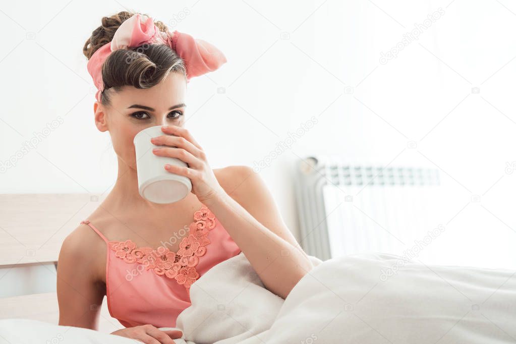 Beautiful woman sipping her morning coffee still in bed