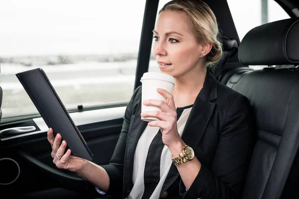 Pengusaha wanita melihat tablet digital di mobil — Stok Foto