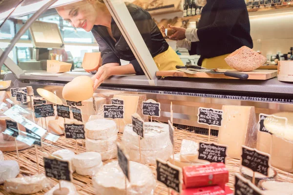 Winkel bediende vrouw kaas in de supermarkt-weergave sorteren — Stockfoto