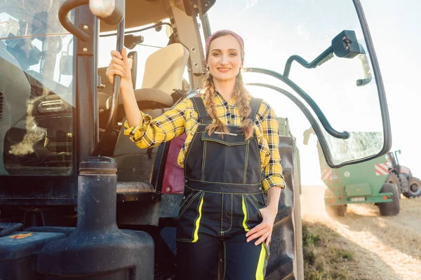 Rolnik kobietę stojącą przed ciągnikiem na polu pszenicy — Zdjęcie stockowe