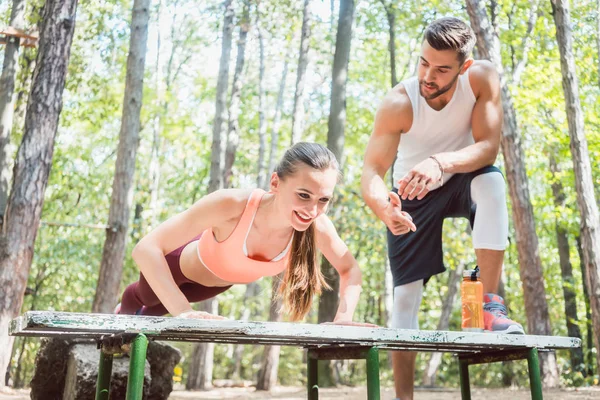 Sporty woman doing push-up in an outdoor gym — Stock Photo, Image