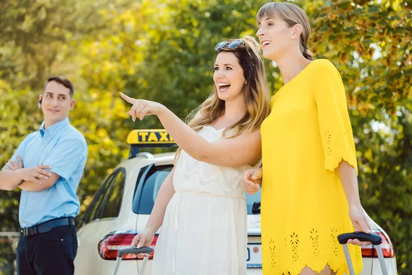 Frauen mit Gepäck steigen ins Taxi — Stockfoto