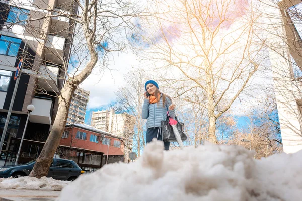 Mujer caminando a través de nieve derretida a finales del invierno — Foto de Stock