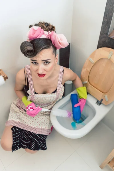 La ama de casa no se divierte en absoluto limpiando el baño. — Foto de Stock