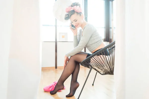 Woman at home wearing stockings taking a call on her mobile phone — Stock Photo, Image
