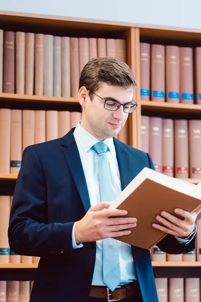 Anwalt in seinem Büro liest Präzedenzfälle in dicken Büchern — Stockfoto