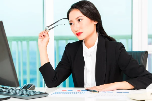 Nachdenkliche Geschäftsfrau blickt auf Computer — Stockfoto