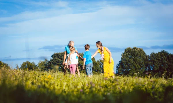 Två kvinnor med barn spela tagg — Stockfoto