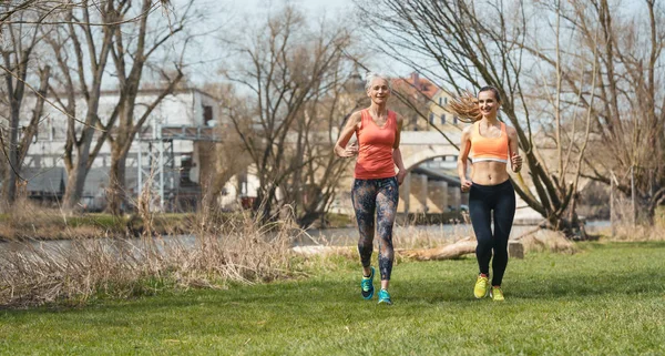 Mujer vieja y joven corriendo por el deporte en el día de primavera —  Fotos de Stock