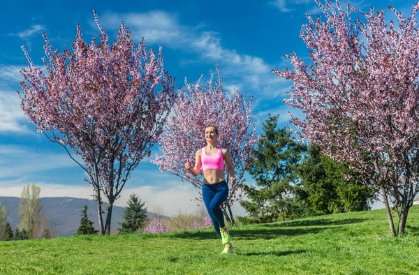 Mulher que tem corrida fitness no sol de primavera — Fotografia de Stock