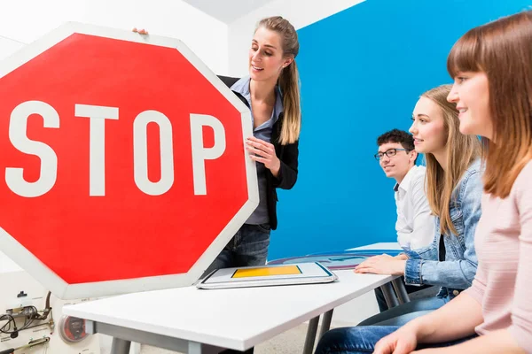 Profesor de conducción explicando el significado de las señales de calle a la clase —  Fotos de Stock