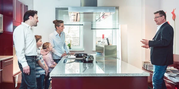 Expert explaining new kitchen to family looking for one — Stock Photo, Image