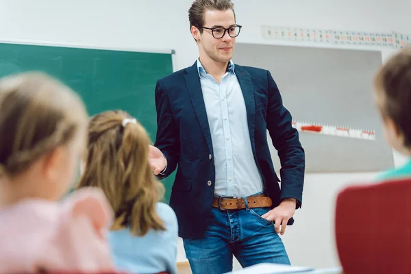 Nauczyciel stoi przed uczniów w szkole Klasa — Zdjęcie stockowe