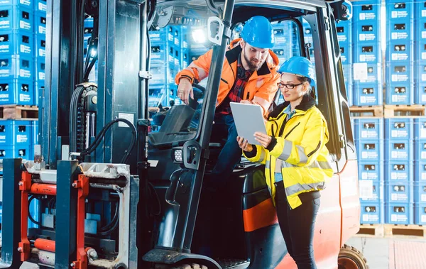 Trabajadores en almacén logístico revisando el inventario — Foto de Stock