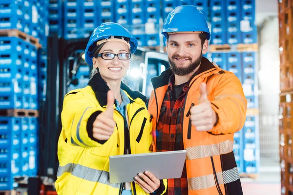 Trabajadores en centro de distribución logística mostrando pulgares hacia arriba — Foto de Stock