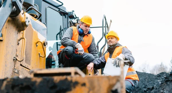 Foreman visar arbetare i dagbrott grop riktning — Stockfoto