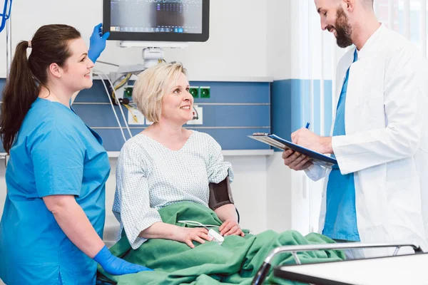 Paciente en la sala de recuperación del hospital hablando con el médico — Foto de Stock