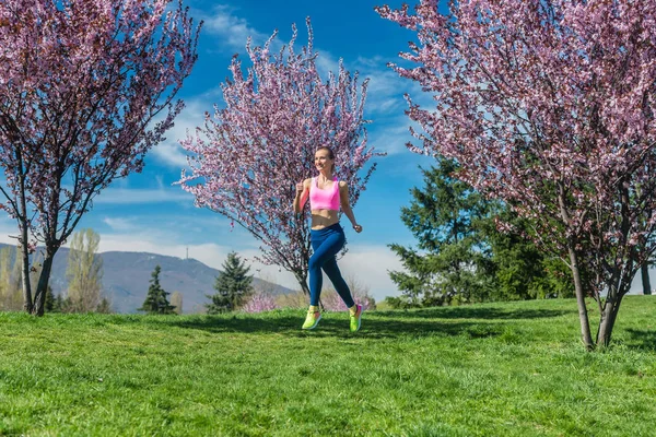 Жінка біжить за фітнес на весняний день — стокове фото