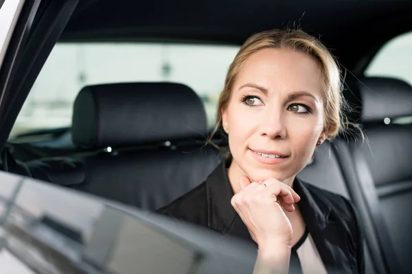 Nachdenkliche Geschäftsfrau sitzt im Auto — Stockfoto