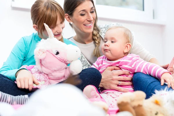 Madre jugando con el bebé y su hija mayor — Foto de Stock