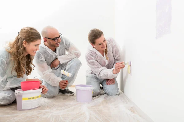 Par kvinna målning på väggen och tittar — Stockfoto