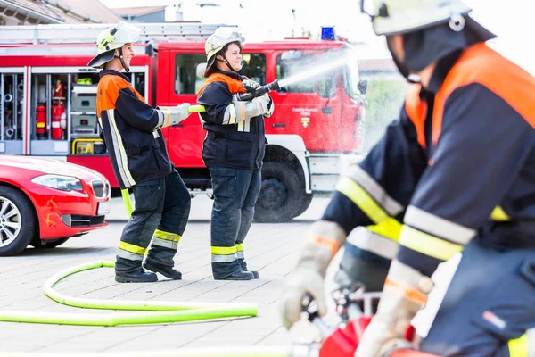 Bomberos conectando mangueras — Foto de Stock