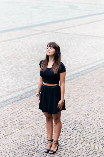 Elegante giovane donna in piedi su ciottoli — Foto Stock